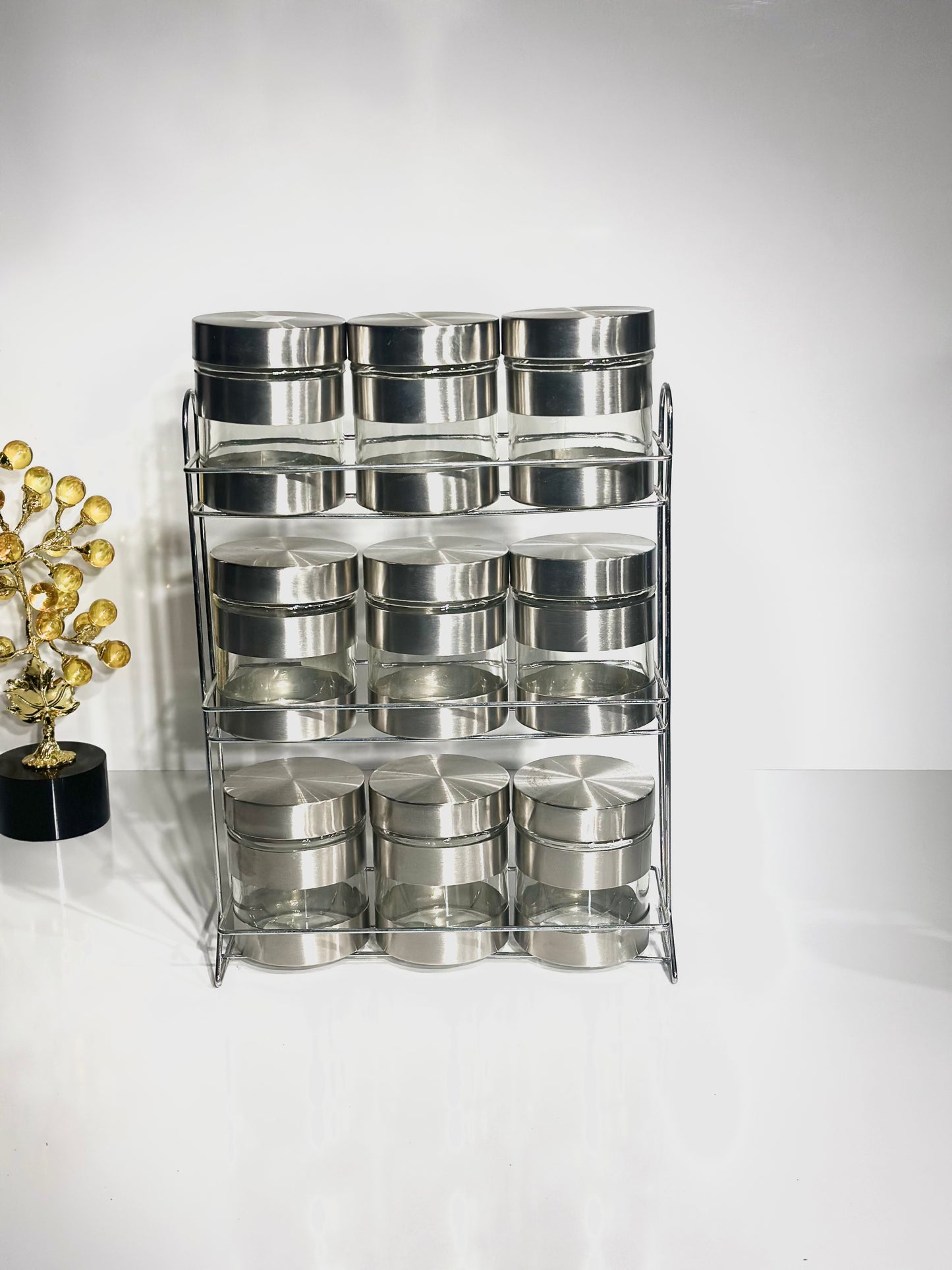 Un ensemble de 12 pieces en gris marbré , 2 bouteille à huile, et le reste des boites de rangements entre épices et céréales. Le tout est posé sur un support en doré en acier inoxydable